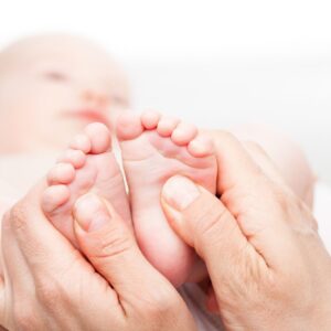 chiropractor massaging a baby's feet