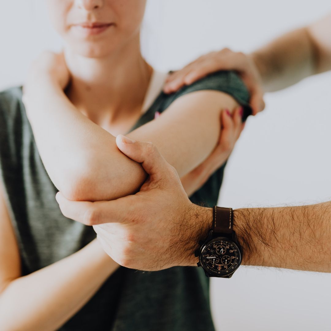 Chiropractor adjusting woman's shoulder