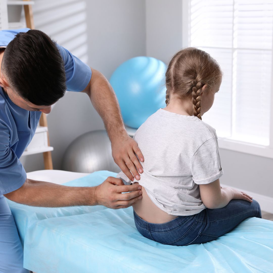 Chiropractor examining child's back